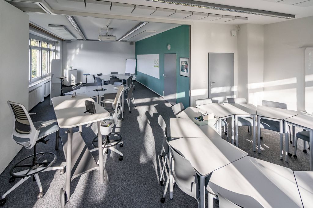 Schulungsraum mit mobilen Einzeltischen in Sitzhöhe und rollbaren Stühlen